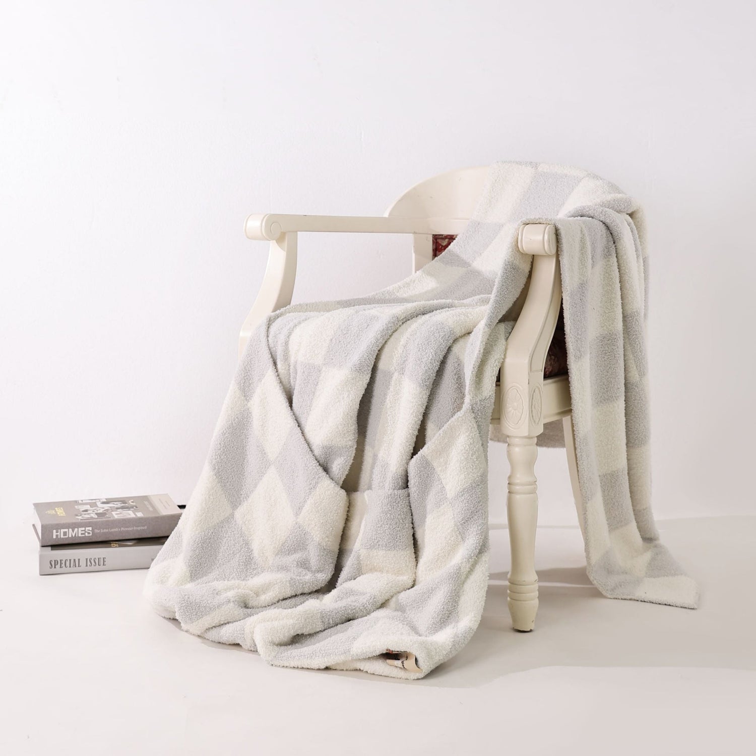 White chair with a gray blanket draped over it on a white background. the blanket is  feet long by 4 feet wide, with a 2 foot pouch sewn at the bottom