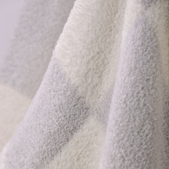 Close-up of textured fabric with a gradient from light to dark gray. Ultra soft